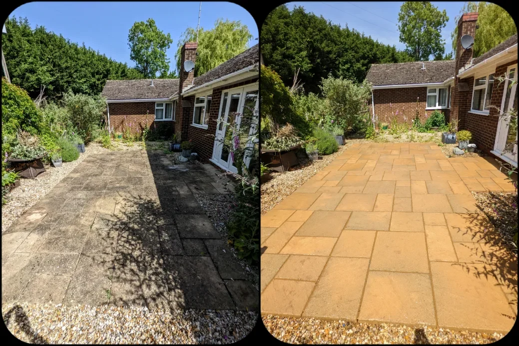 Person in waterproof boots cleaning patio with a pressure washer, water splashing.